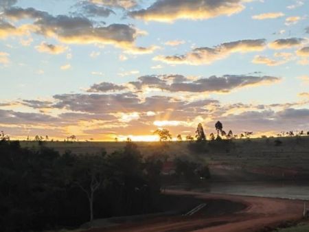 Legenda: Vista do loteamento Fazenda da Matta sob pôr do sol no Cerrado, cenário que reforça a vocação da região para empreendimentos de segunda residência e alto padrão.