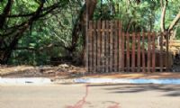 Sangue da vítima no asfalto, em frente a barraco. (Foto: Juliano Almeida/Campo Grande News)